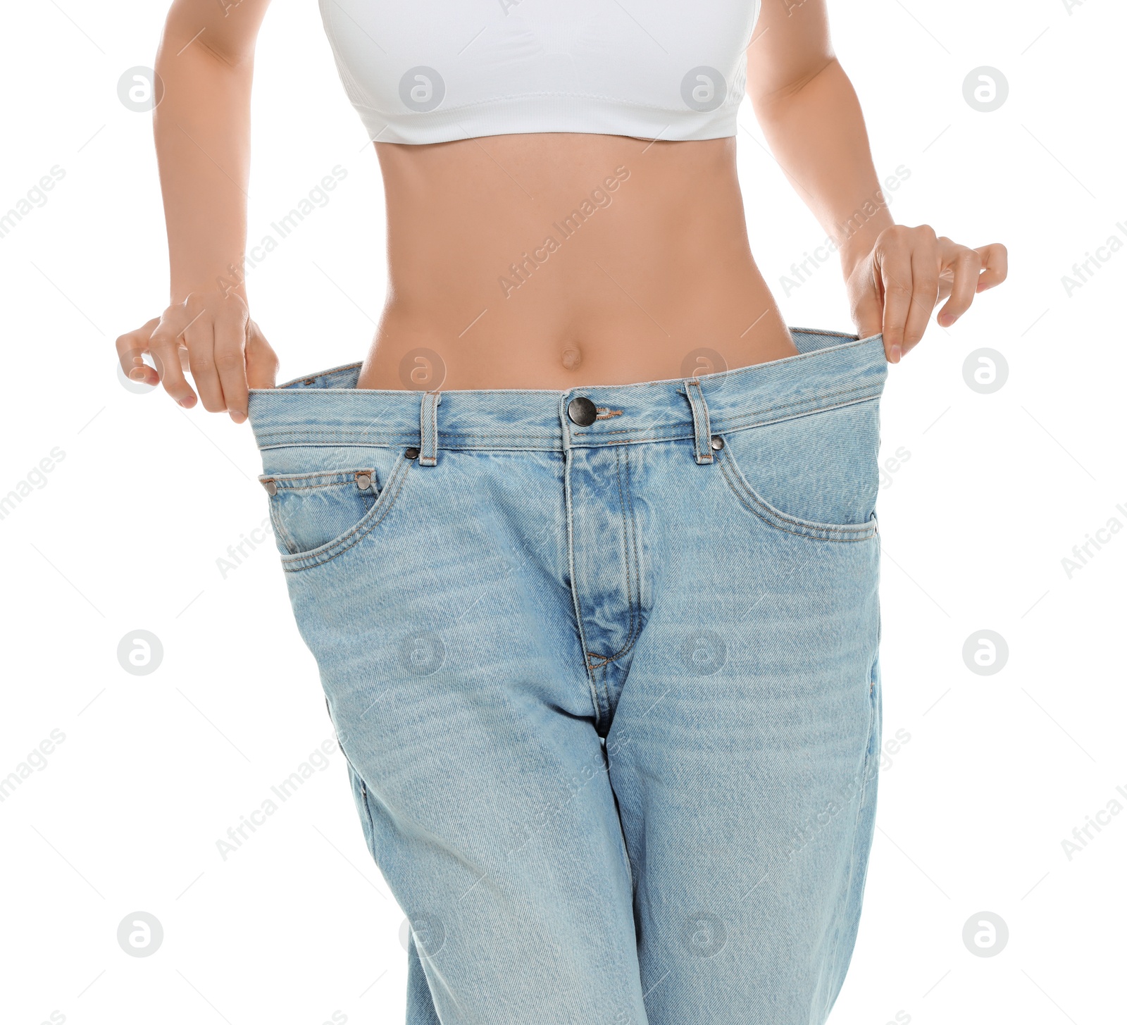 Photo of Slim young woman with smooth gentle skin in oversized jeans on white background, closeup. Beauty and body care concept