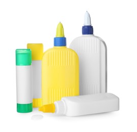 Different bottles and sticks of glue on white background