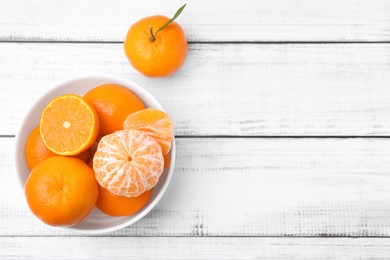 Photo of Fresh juicy tangerines on white wooden table, flat lay. Space for text
