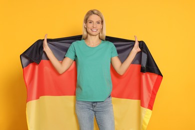 Photo of Woman with flag of Germany on yellow background
