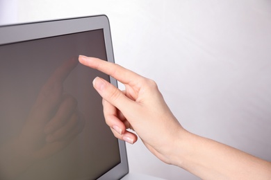 Woman using modern laptop on light background, closeup
