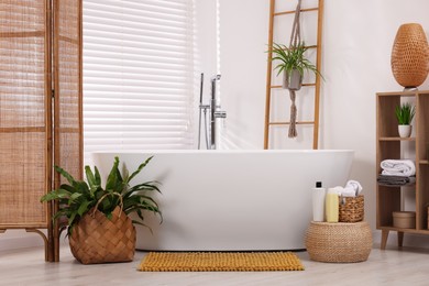 Photo of Stylish bathroom interior with soft bath mat and tub