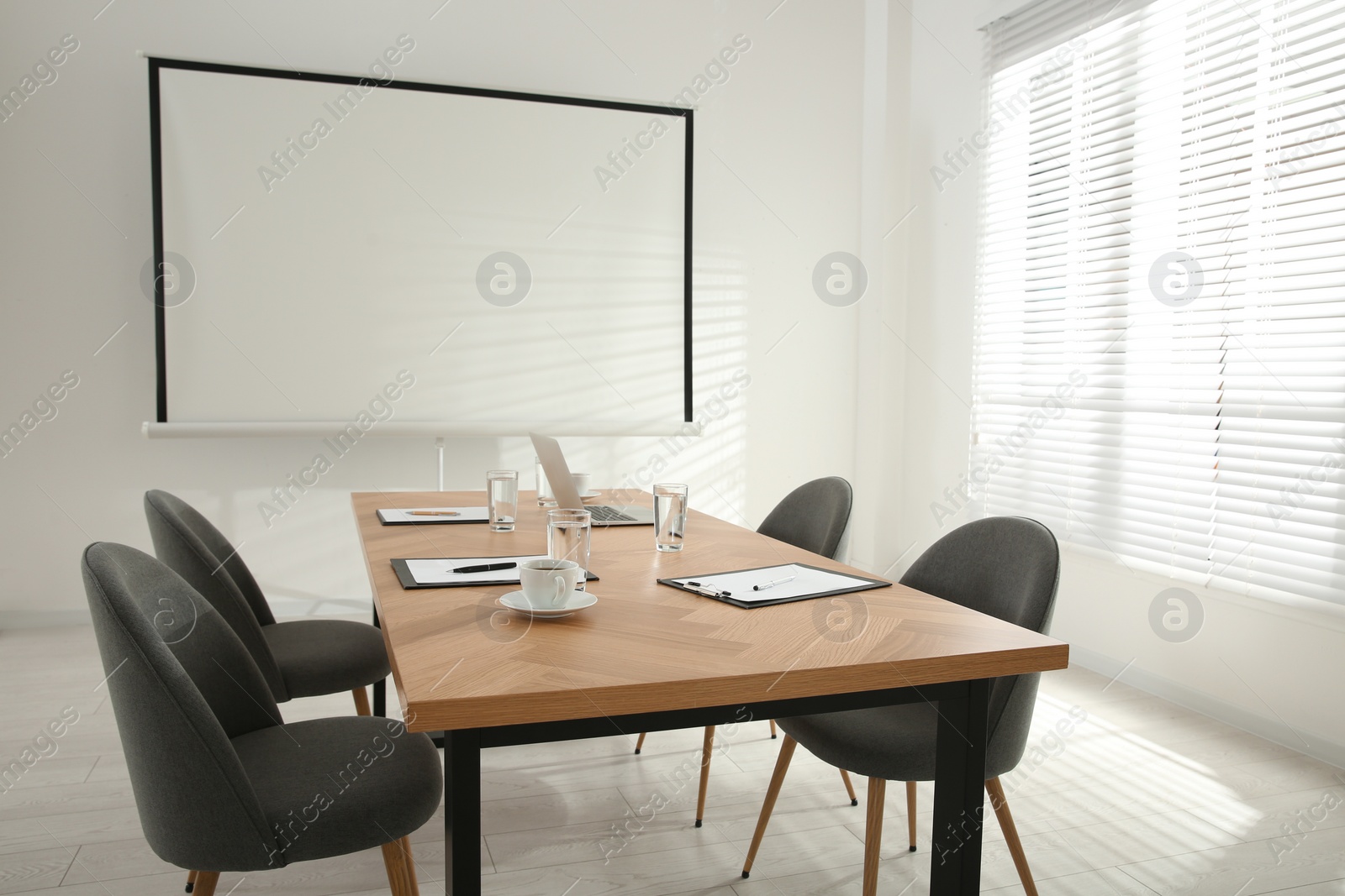 Photo of Conference room interior with wooden table and video projection screen