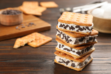 Sweet delicious ice cream cookie sandwiches on wooden table. Space for text