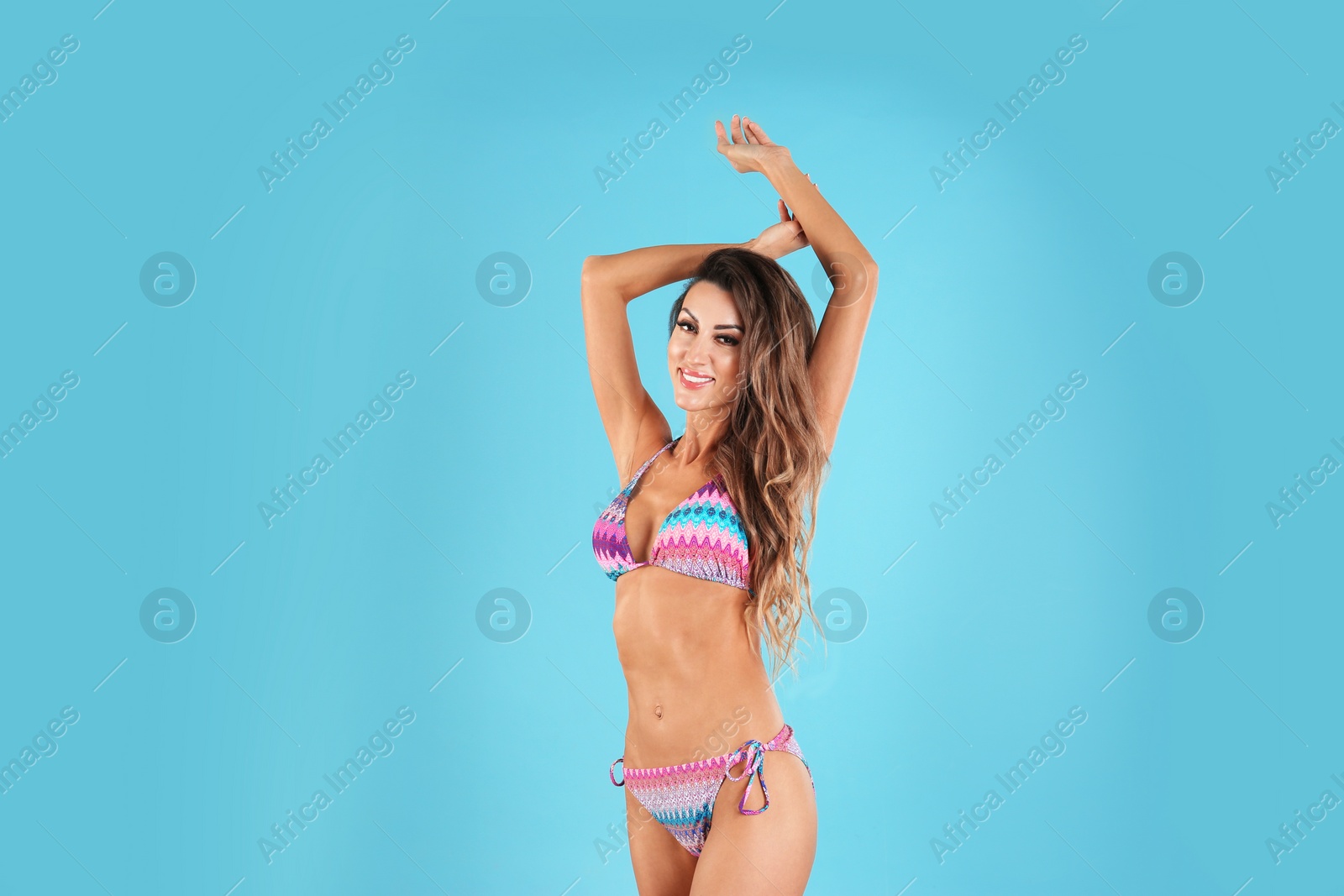 Photo of Pretty sexy woman with beautiful slim body in stylish bikini on color background