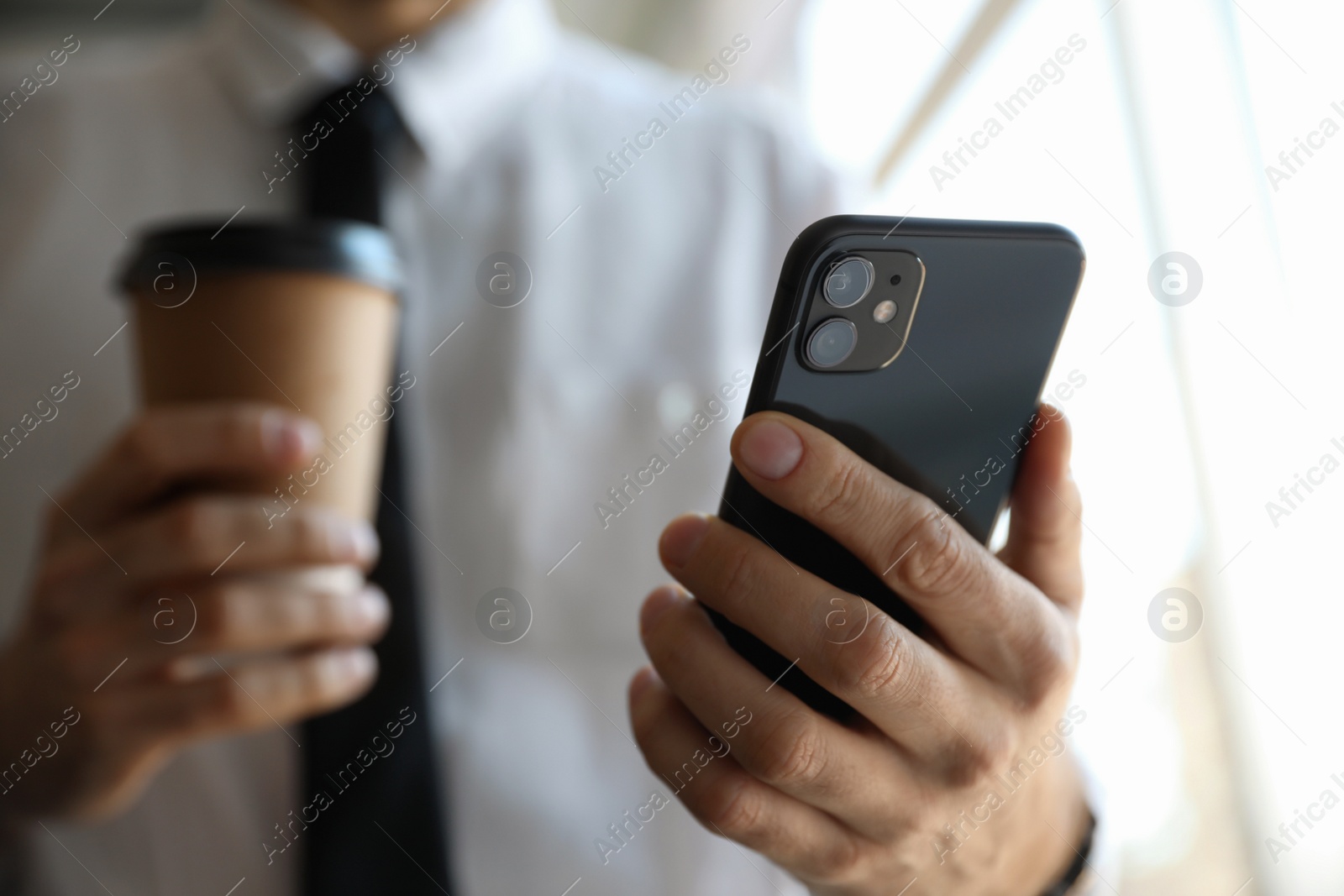 Photo of MYKOLAIV, UKRAINE - MARCH 16, 2020: Man holding iPhone 11 Black indoors, closeup