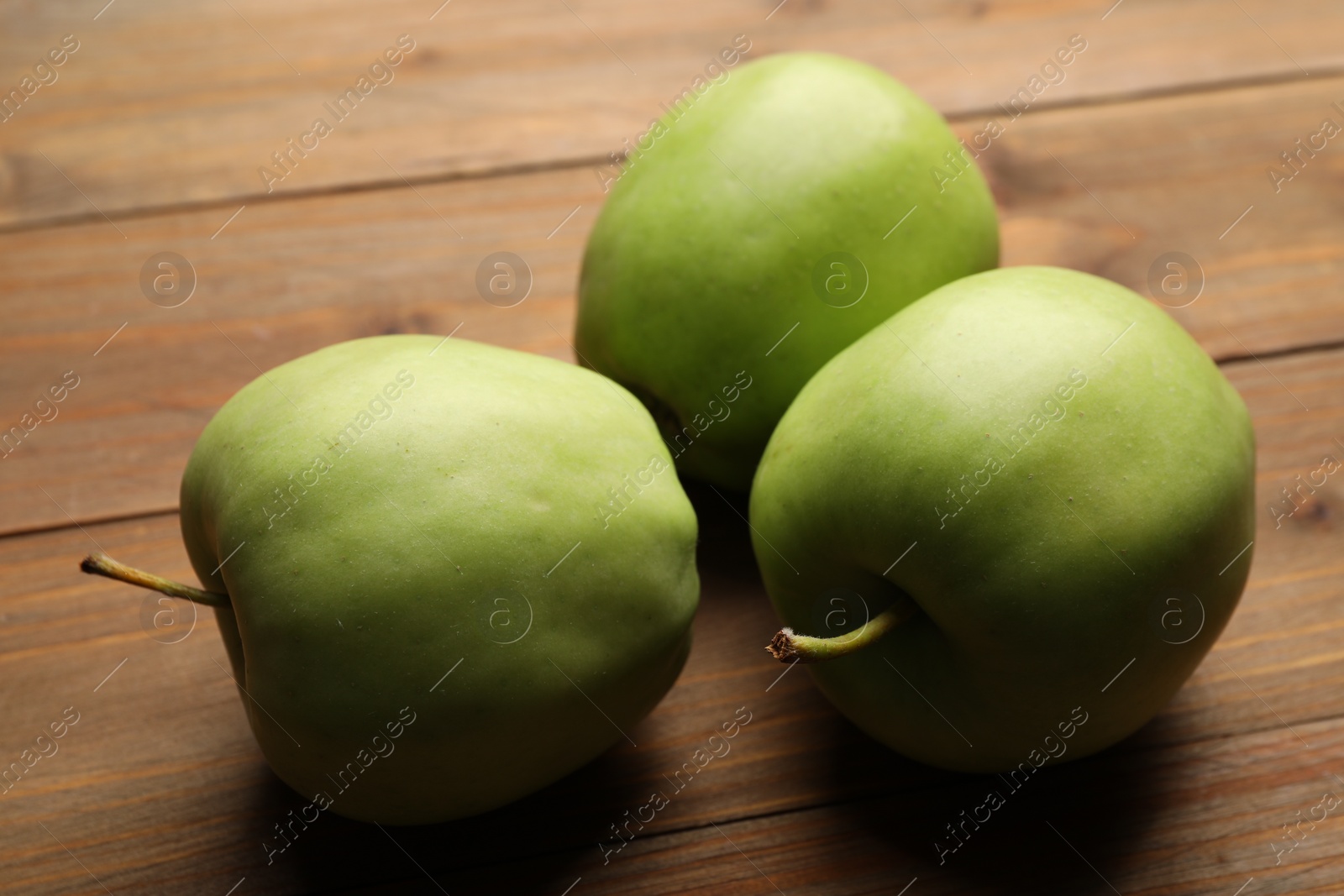Photo of Fresh green apples on wooden table, closeup