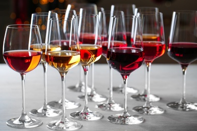 Group of glasses with different wines on table against blurred background