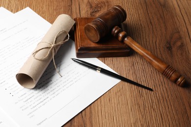 Photo of Documents, fountain pen and gavel on wooden table. Notary contract