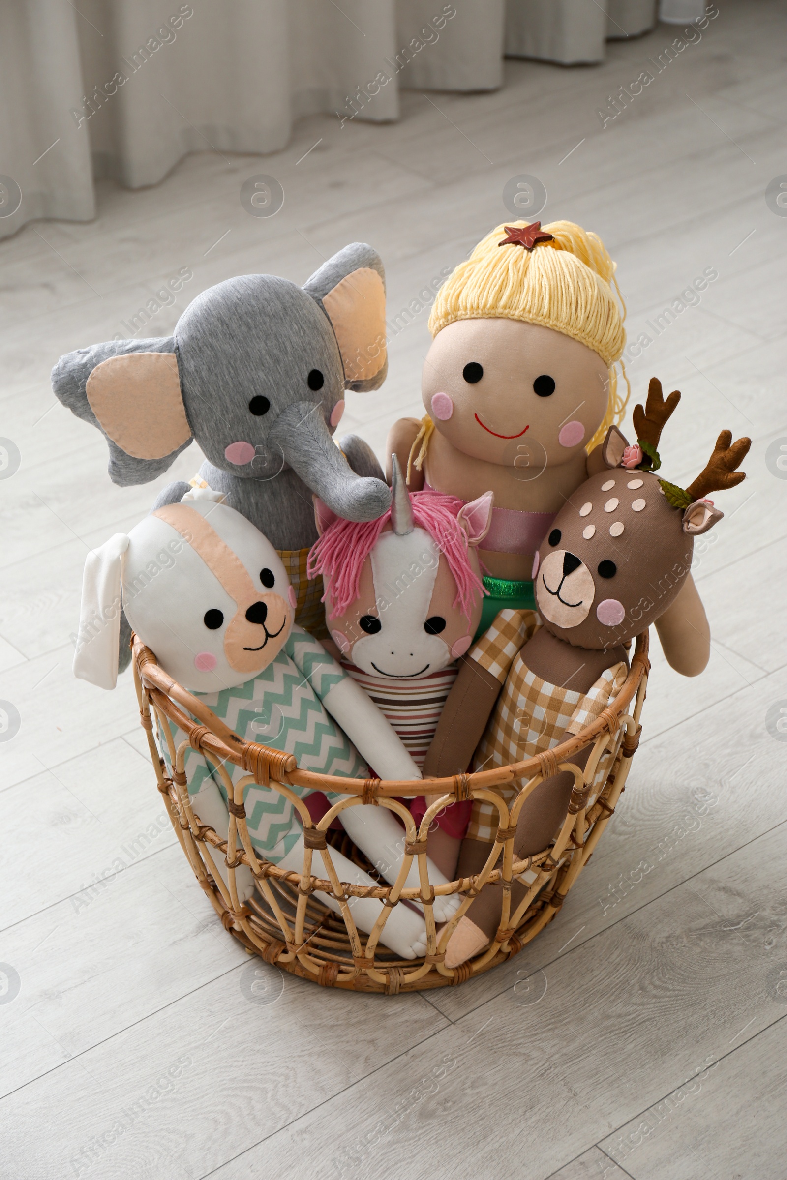 Photo of Funny toys in basket on floor. Decor for children's room interior