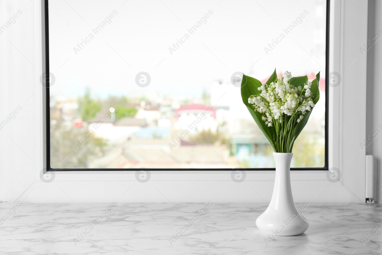 Photo of Beautiful lily of the valley bouquet in vase on windowsill, space for text