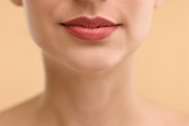 Photo of Woman with beautiful lips on beige background, closeup