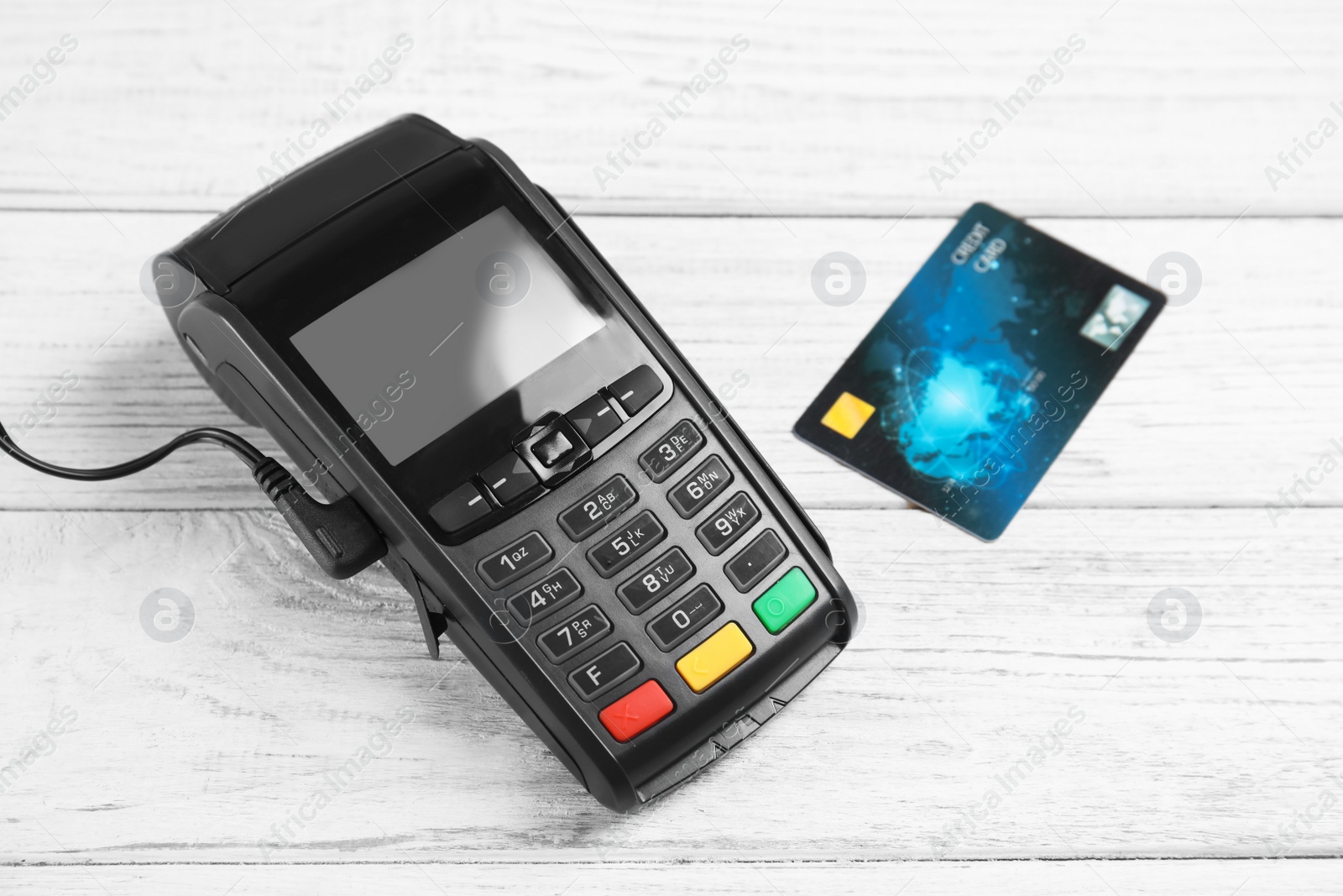 Photo of Modern payment terminal and credit card on white wooden background