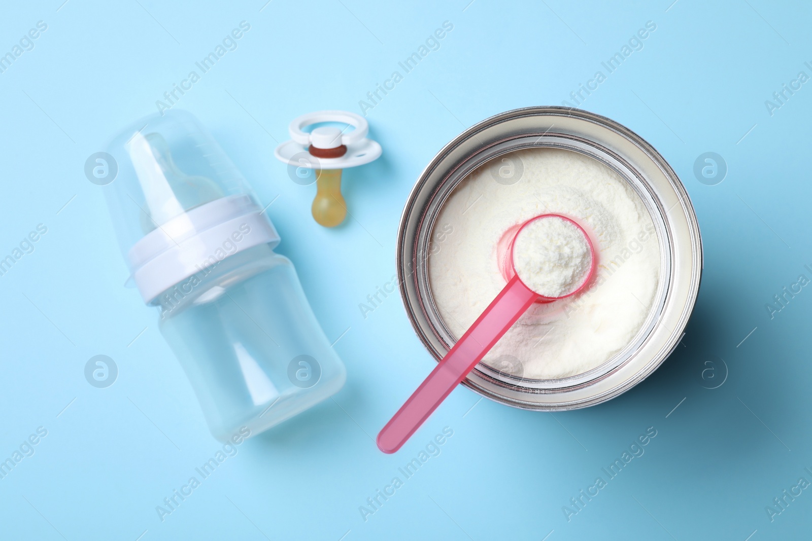 Photo of Flat lay composition with powdered infant formula on light blue background. Baby milk