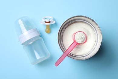 Photo of Flat lay composition with powdered infant formula on light blue background. Baby milk