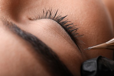 Young woman undergoing procedure of permanent eye makeup in tattoo salon, closeup