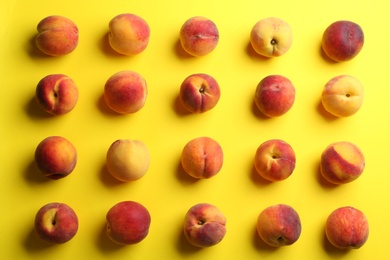 Photo of Fresh ripe peaches on yellow background, flat lay