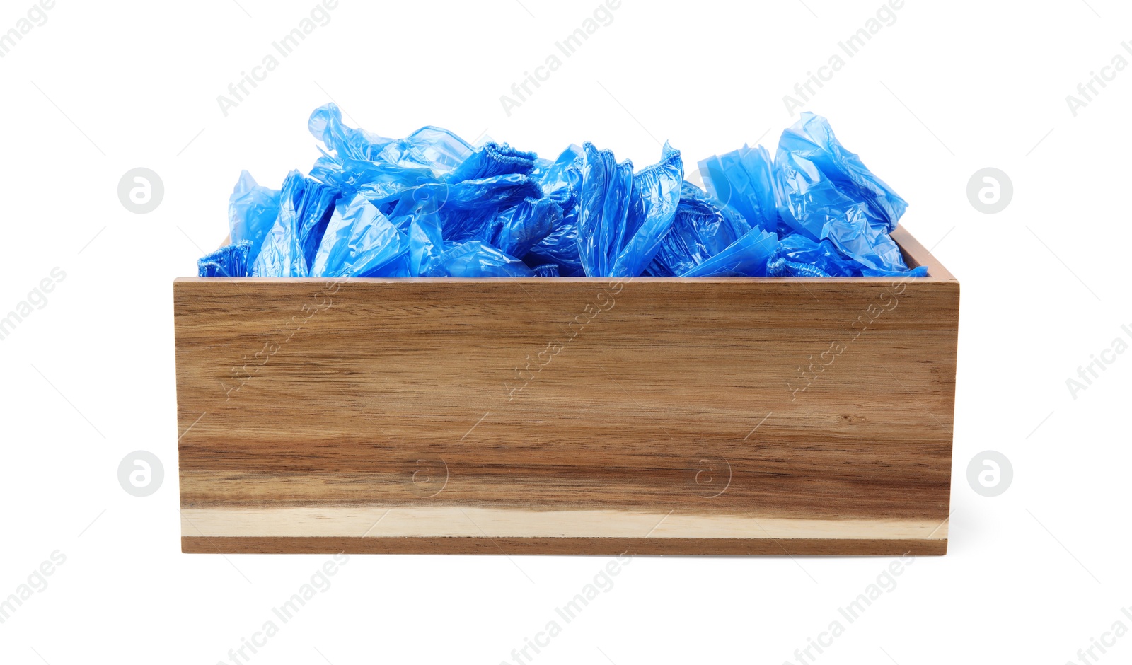 Photo of Blue medical shoe covers in wooden crate isolated on white