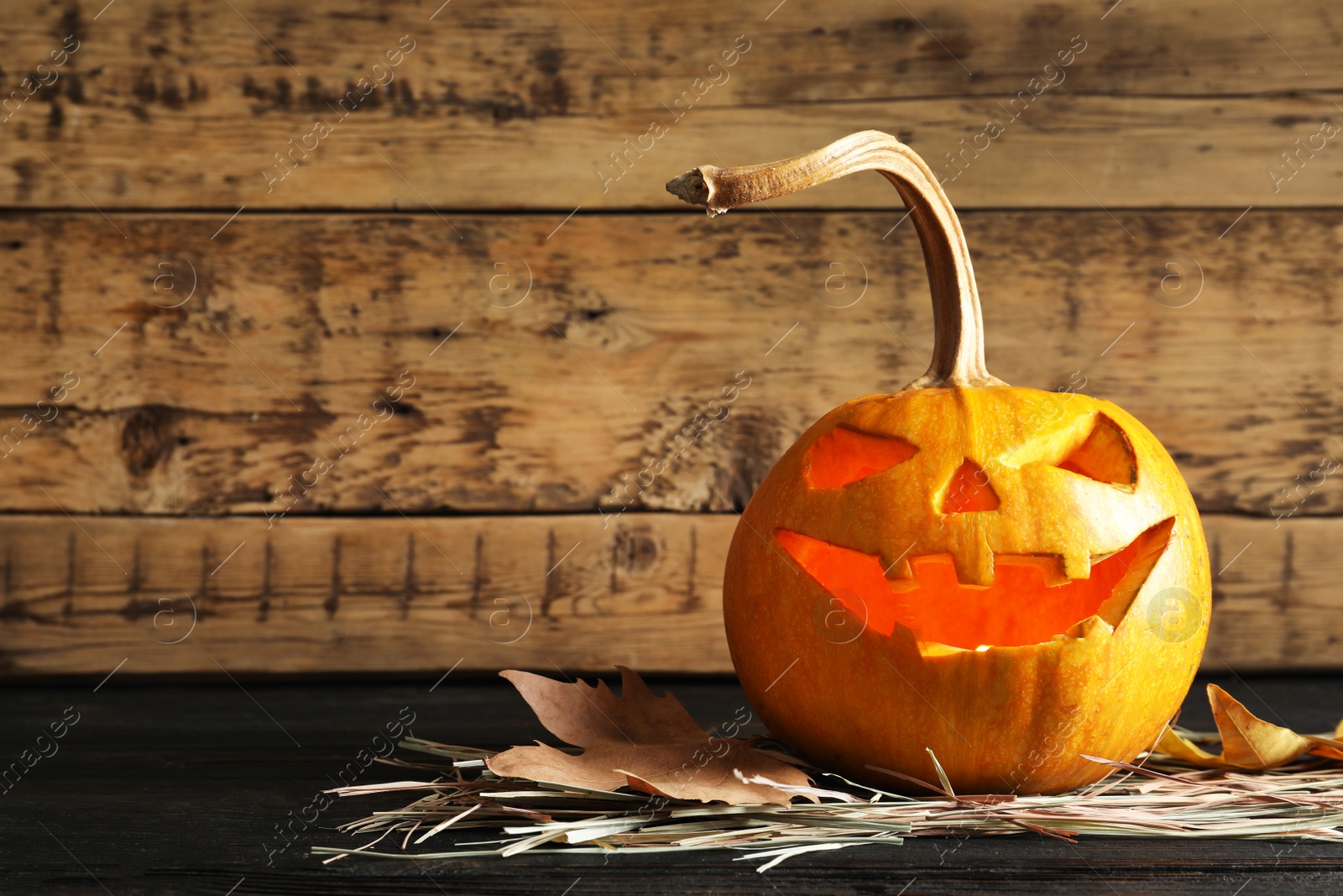 Photo of Halloween pumpkin head jack lantern on table against wooden background with space for text