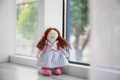 Photo of Abandoned doll on window sill. Time to visit child psychologist
