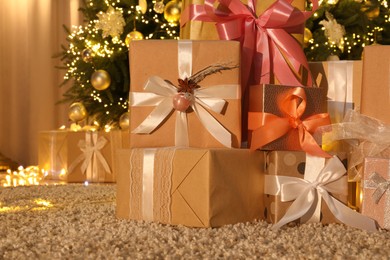 Many gift boxes near decorated Christmas tree at home