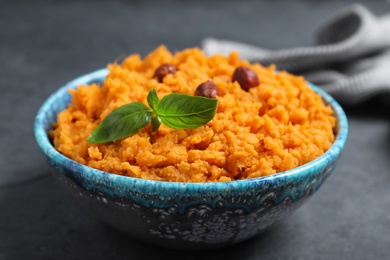 Photo of Bowl with mashed sweet potatoes on grey table