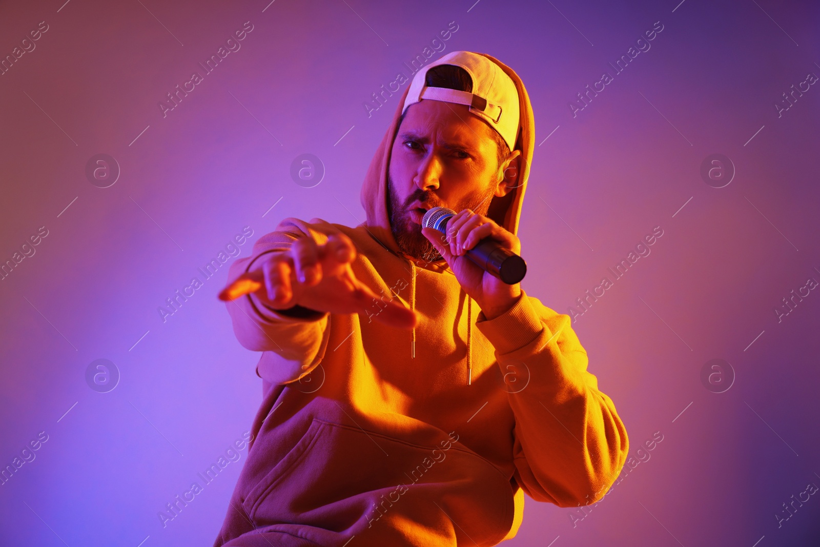 Photo of Singer with microphone rapping in color lights