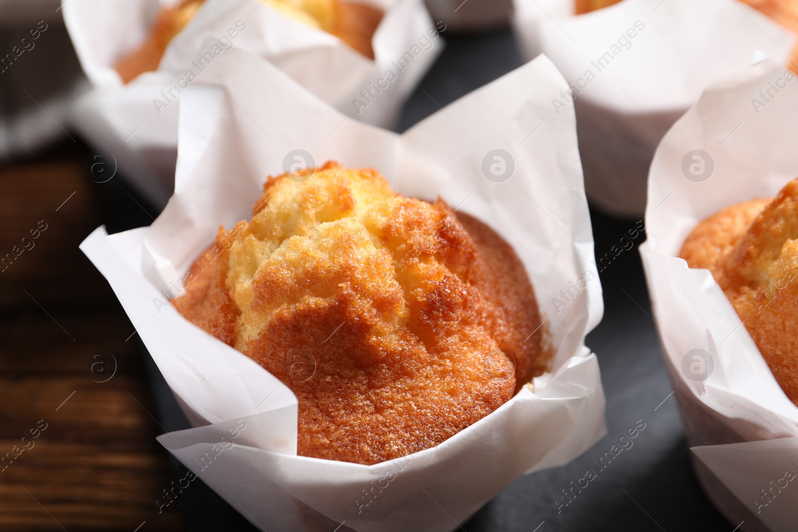 Photo of Delicious sweet muffins on wooden table, closeup