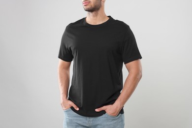 Photo of Man wearing black t-shirt on gray background, closeup