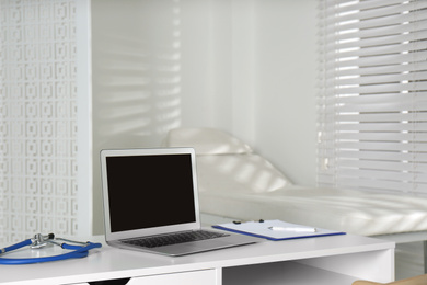 Doctor's workplace with laptop in modern clinic