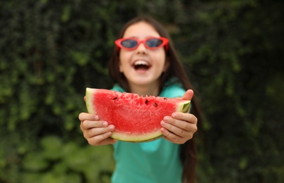 Photo of Cute little girl outdoors, focus on hands with watermelon