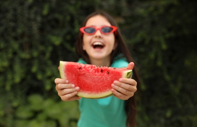 Cute little girl outdoors, focus on hands with watermelon