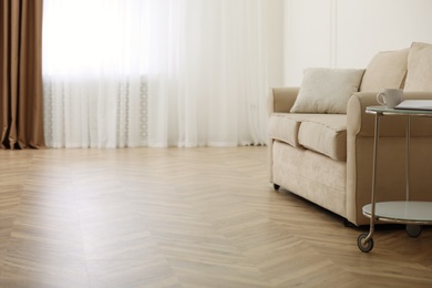 Photo of Parquet floor in room with sofa and coffee table