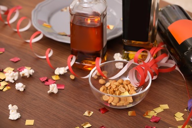 Photo of Messy table with popcorn, bottles and streamers after party