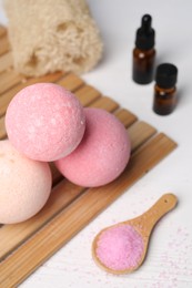 Photo of Beautiful aromatic bath bombs and sea salt on white wooden table, closeup