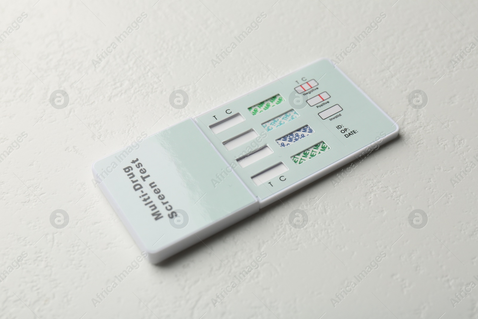 Photo of Multi-drug screen test on white textured table, closeup