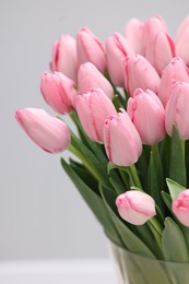 Photo of Bouquet of beautiful pink tulips on grey background, closeup