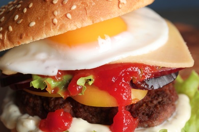 Photo of Closeup view of tasty burger with fried egg