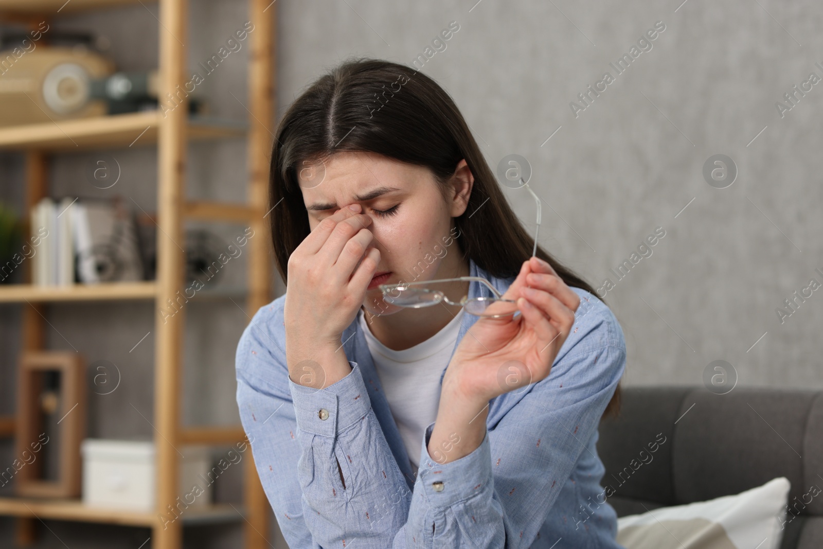 Photo of Overwhelmed woman with glasses suffering at home