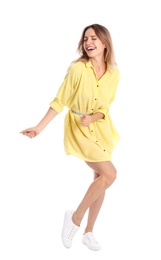 Beautiful young woman in yellow dress dancing on white background