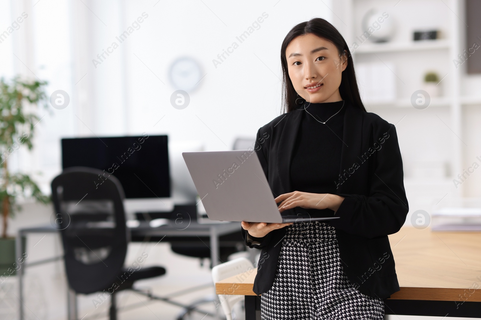 Photo of Portrait of smiling businesswoman with laptop in office. Space for text