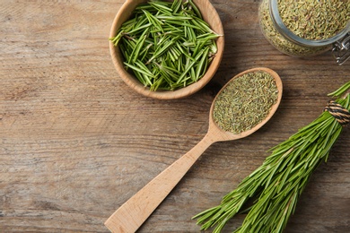 Photo of Dried rosemary and fresh twigs on wooden background, flat lay