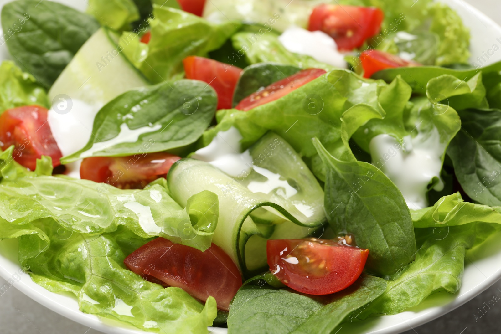 Photo of Delicious vegetable salad in white bowl, closeup