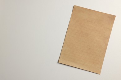 Photo of Sheet of old parchment paper on white background, top view. Space for text