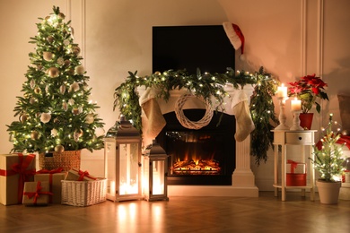 Photo of Beautiful room interior with fireplace and Christmas decor in evening
