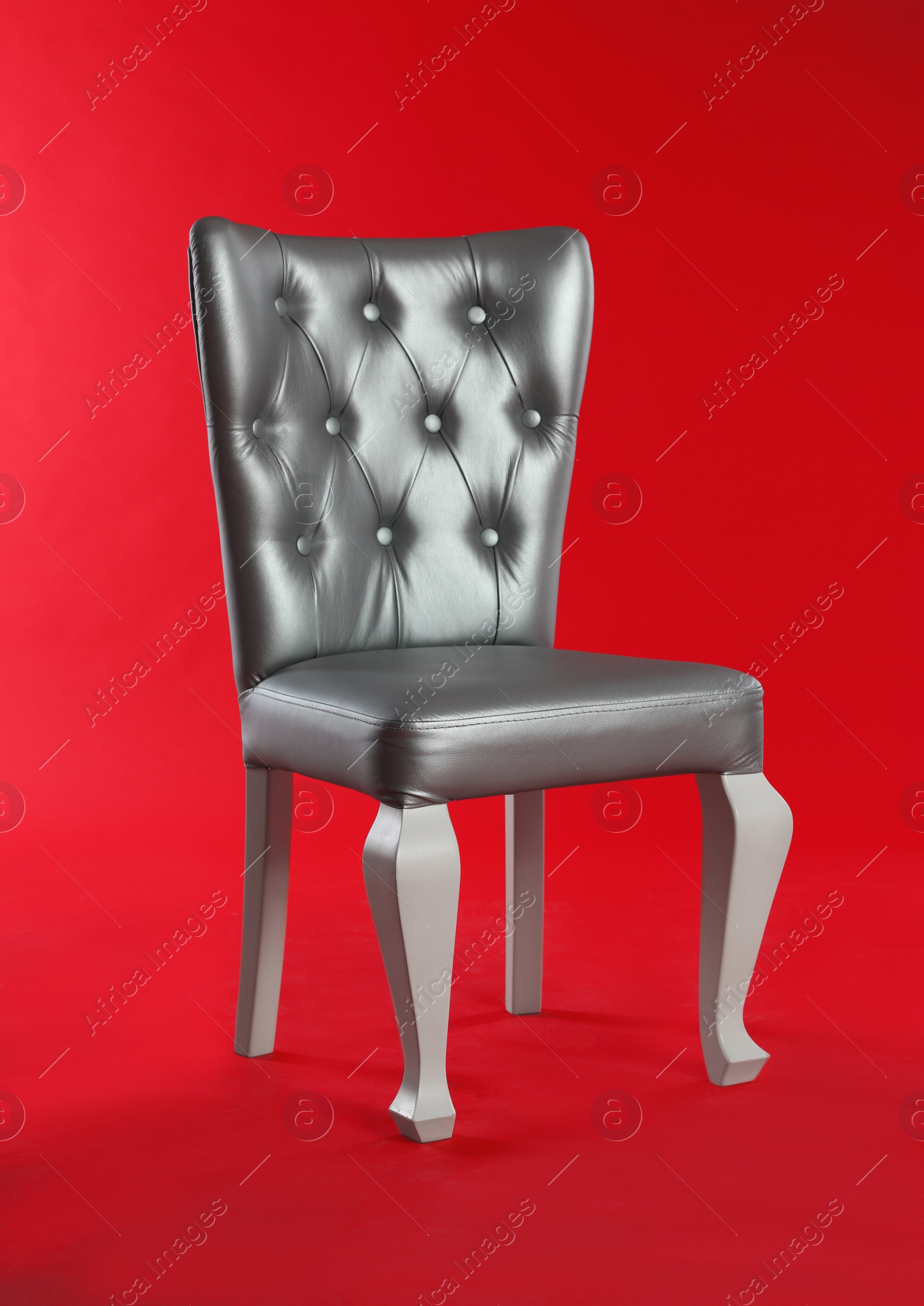 Photo of Stylish silver chair on red background. Element of interior design