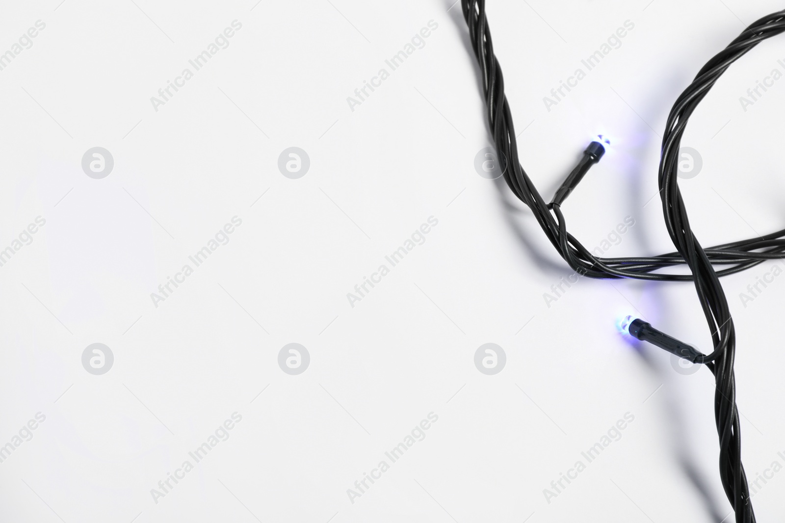 Photo of String of beautiful Christmas lights on white background