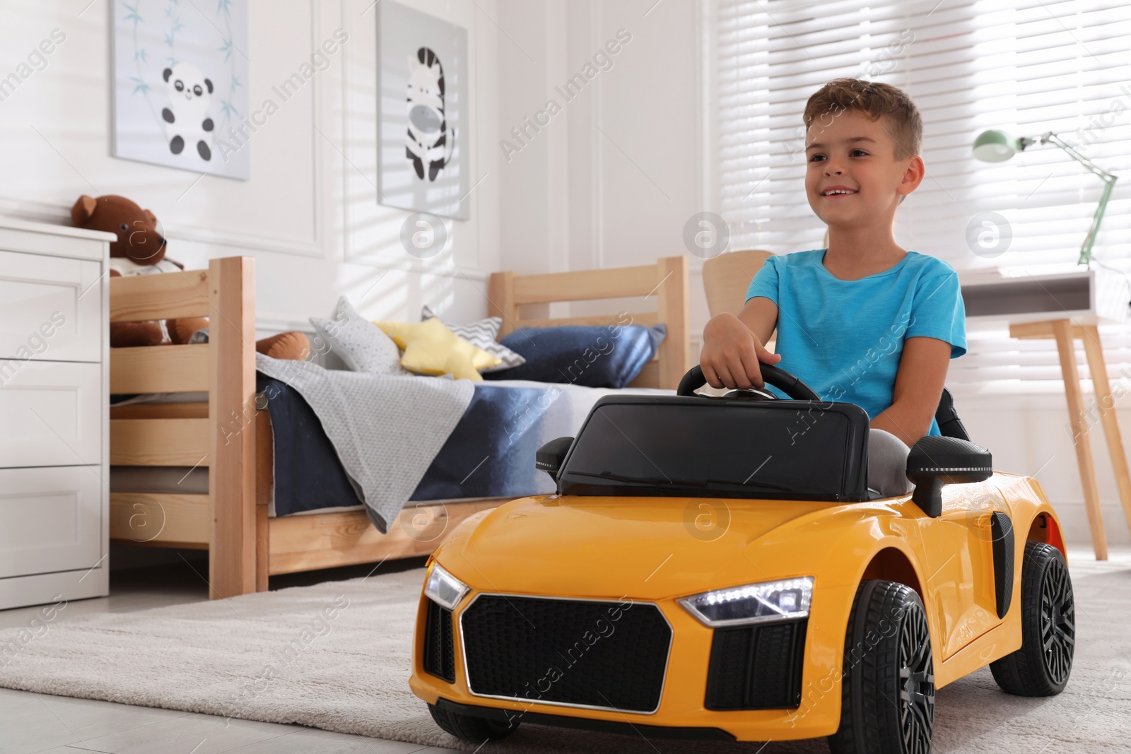 Photo of Cute little boy driving big toy car at home