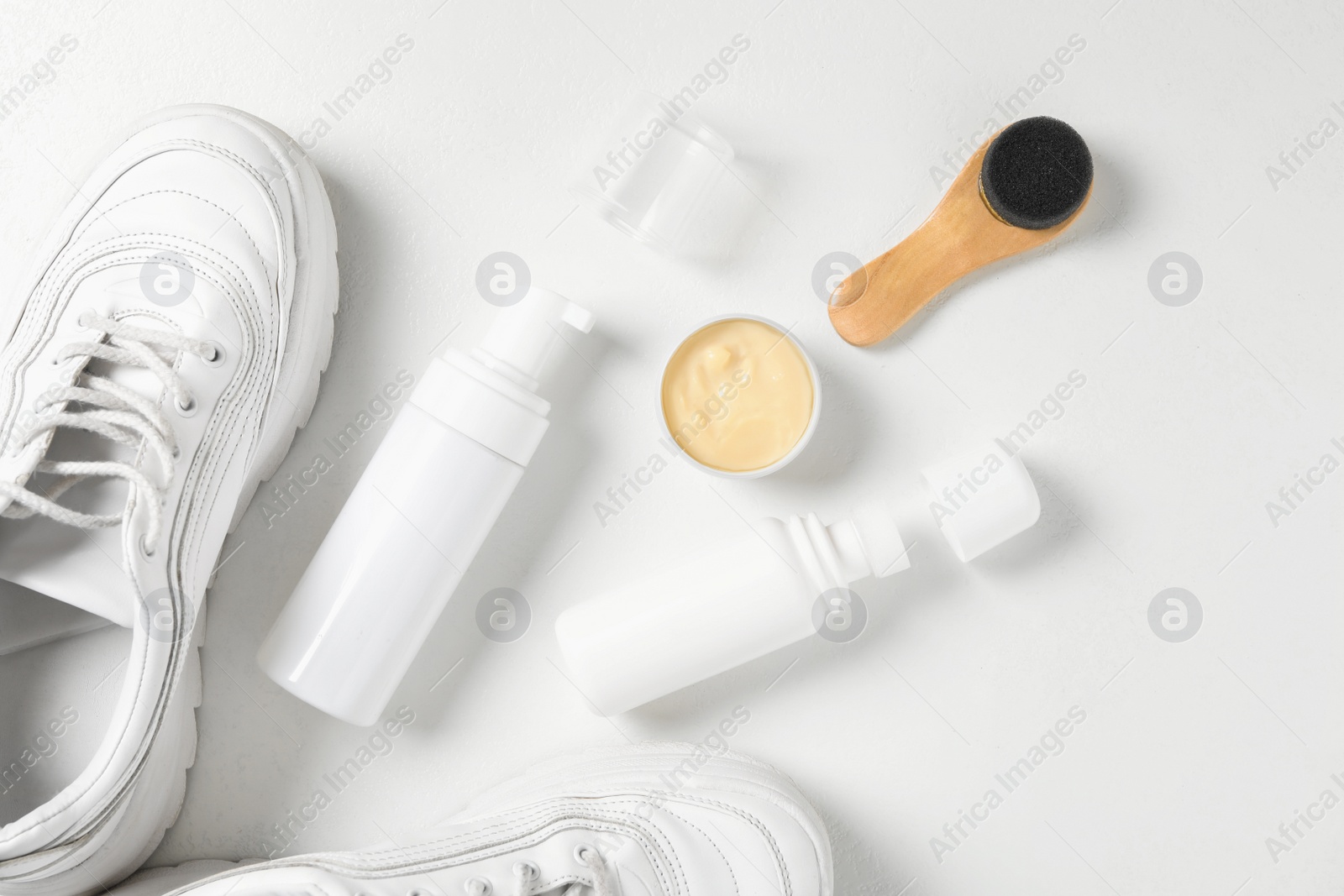 Photo of Flat lay composition with stylish footwear and shoe care accessories on white background