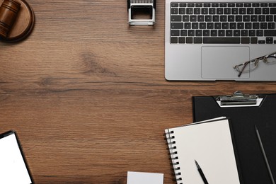 Flat lay composition with laptop and smartphone on wooden table. Space for text